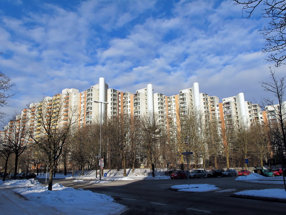 Blick auf die Hochhäuser einer Großwohnsiedlung, davor Bäume und Straßen, die zum Teil mit Schnee bedeckt sind.