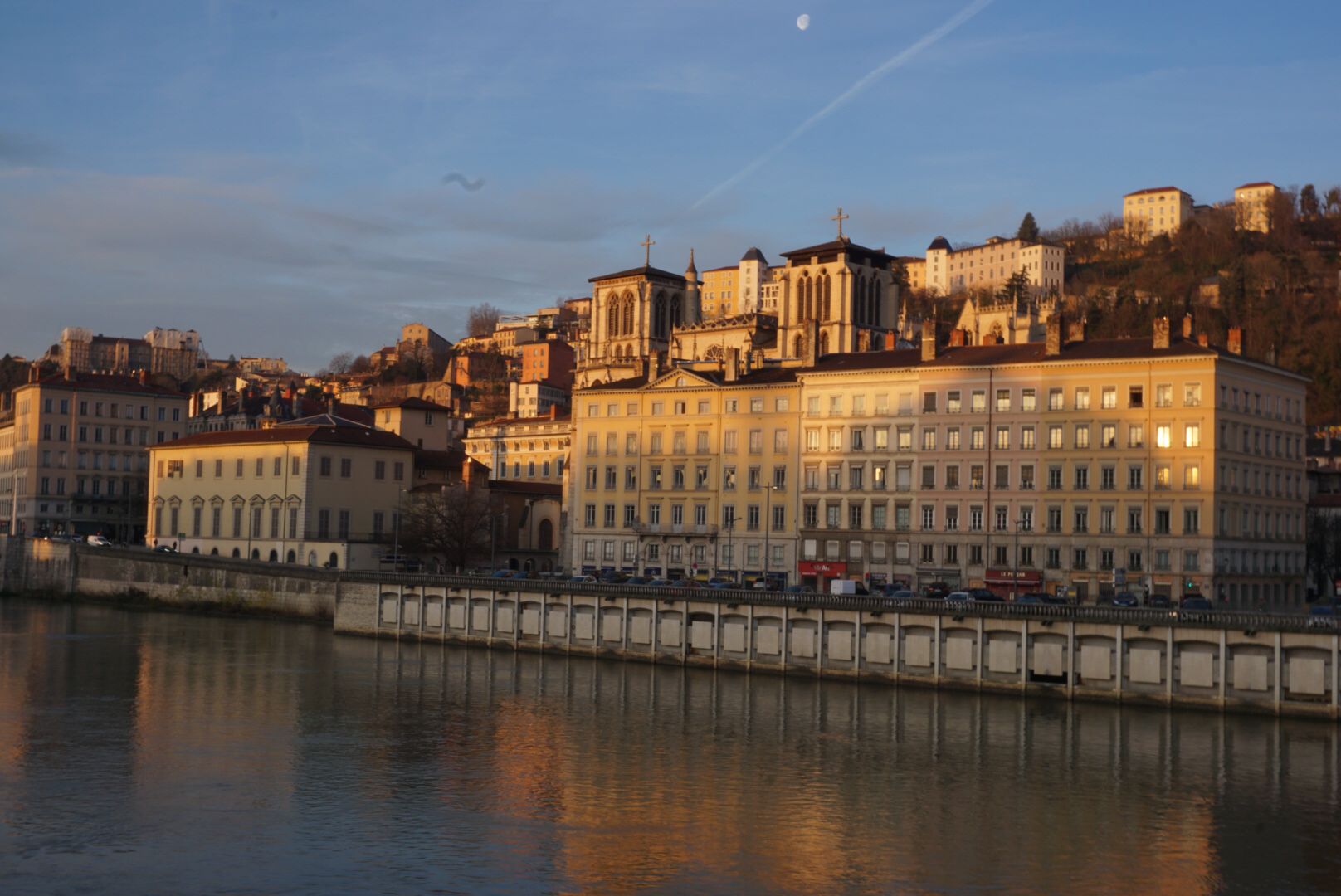 Flussufer mit historischen Gebäuden im Sonnenaufgang