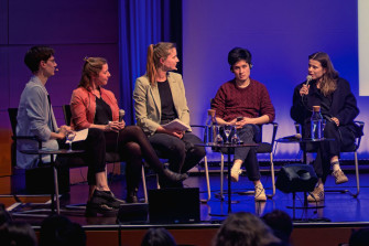Fünf Personen sitzen in Sesseln und unterhalten sich auf einer Konferenzbühne.