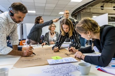 Leute schreiben auf einem Plakat bei einem Workshop